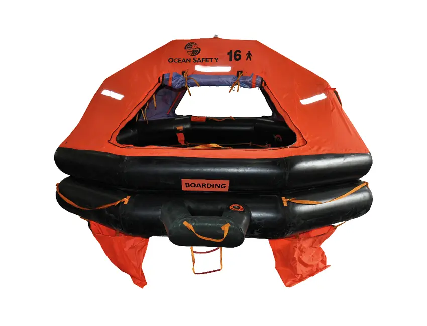 Bright orange inflatable life raft with black base tubes and canopy marked “OCEAN SAFETY 16.” Entry opening with “BOARDING” label, rope ladder, and orange ropes for visibility and stability